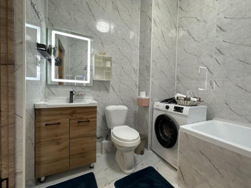 アルマトイにあるШикарная квартира в ЖК Премиум-классаのバスルーム(洗面台、トイレ、洗濯機付)