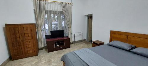 Schlafzimmer mit einem Bett und einem Flachbild-TV in der Unterkunft Omah Tegal Panggung 44 in Sentool