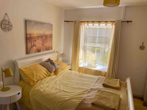 a bedroom with a bed and a window at Pretty Neyland Cottage central to all attractions in Milford Haven