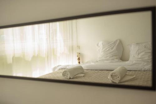 Spiegelreflexion eines Bettes mit zwei weißen Kissen in der Unterkunft Chez Moltess in Seignosse