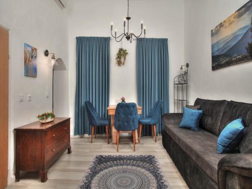 a living room with a couch and a table with chairs at אבני החושן - סוויטות יוקרה בצפת העתיקה - Avnei Hachoshen - Luxury Suites in the Old City in Safed