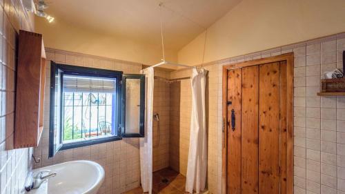 uma casa de banho com uma banheira, um lavatório e uma janela em Asiento del Río Pruna by Ruralidays em Pruna