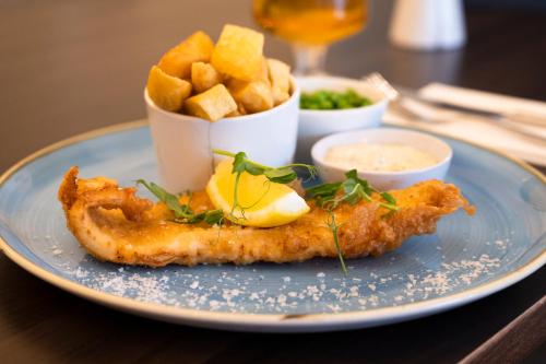a plate of food with fish and chips and sauce at St George's Hotel - Llandudno in Llandudno