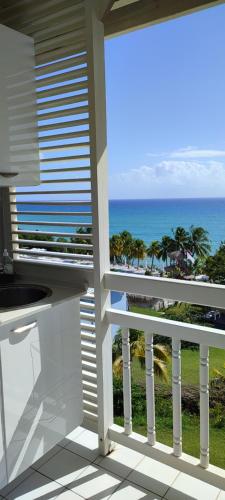 a balcony with a view of the ocean at Un petit joyau in Le Diamant
