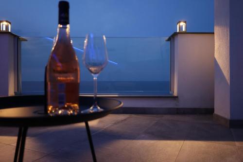 een fles wijn en een glas op een tafel bij Colombo Suites in Peschici