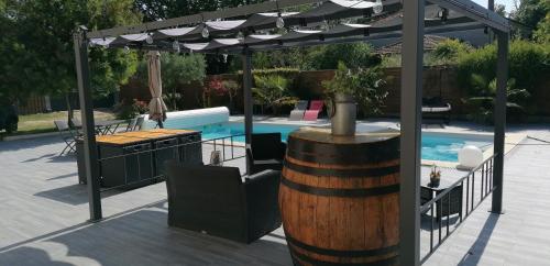 a pergola and a swimming pool with a barrel at La résinière in Salles