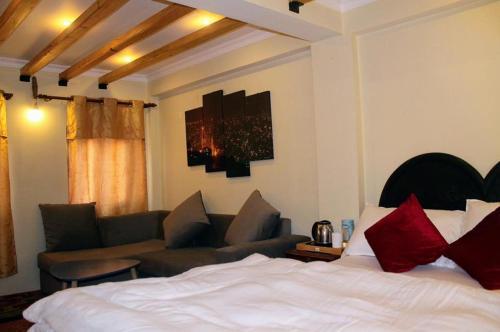 Habitación de hotel con cama y sofá en Peace gallery inn, en Pātan