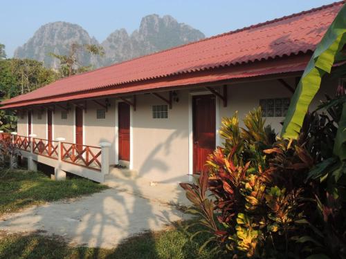 a small white building with a red roof at Maylyn Guesthouse in Vang Vieng