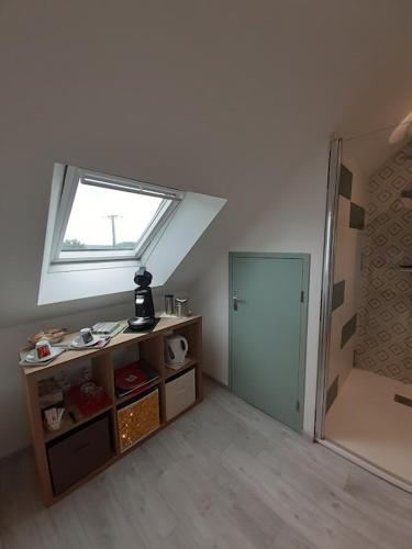 une chambre mansardée avec une fenêtre et une chambre avec une porte dans l'établissement chambre d'hôtes Les Hortensias, à Saint-Jean-la-Poterie