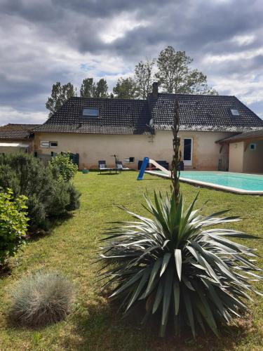 un patio con una casa y una piscina en le bois du bournat, en Saint-Avit-Sénieur