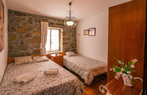 a bedroom with two beds and a window at Leiras de Candoz Douro Valley in Marco de Canaveses