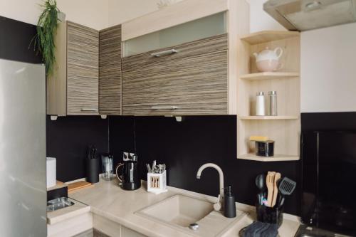 a kitchen with a sink and a black wall at Studio Centrum in Chełm