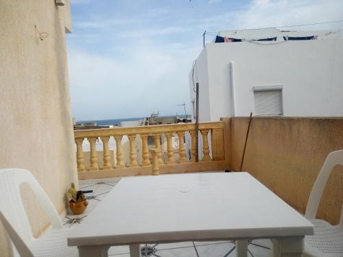 Biały stół i krzesła na balkonie w obiekcie Chez Karim w mieście Mahdia