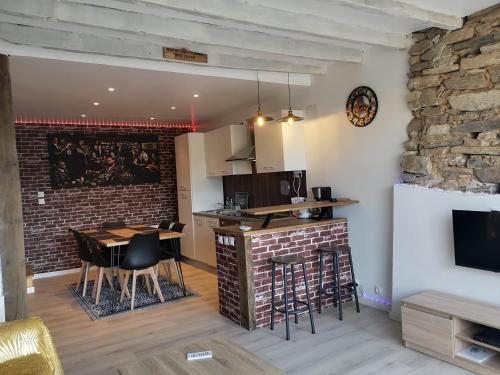 eine Küche und ein Esszimmer mit Ziegelwand in der Unterkunft EssenCiel du lac III in Éguzon-Chantôme