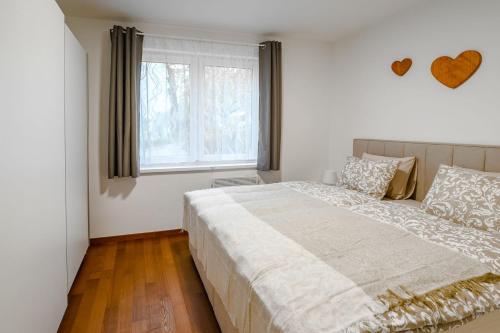 - une chambre avec un grand lit et une fenêtre dans l'établissement Apartma na hribu, à Mojstrana