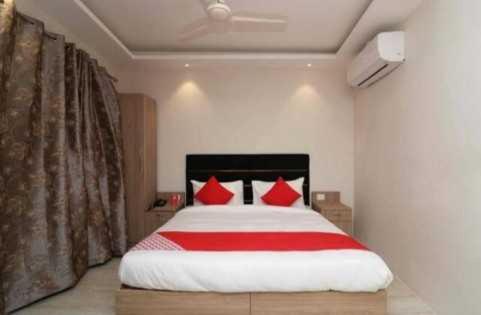 a bedroom with a large bed with red pillows at OYO The Sigma Star in Greater Noida