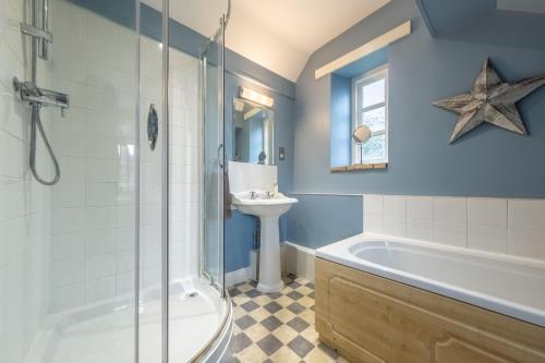 a bathroom with a sink and a tub and a shower at Garden Cottage in Ringstead