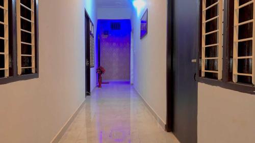 a hallway with a blue light and a door at OYO Four Seasons Hotel in Meerut