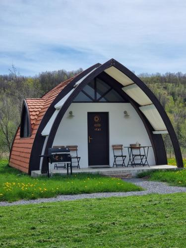 a tent with a table and a grill in a field at Hunnia - Huntanya in Vlăhiţa