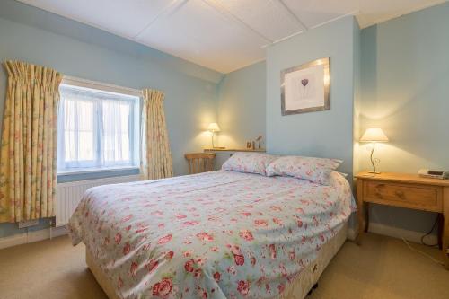 a bedroom with a bed and a window at Plunketts Cottage in Brancaster