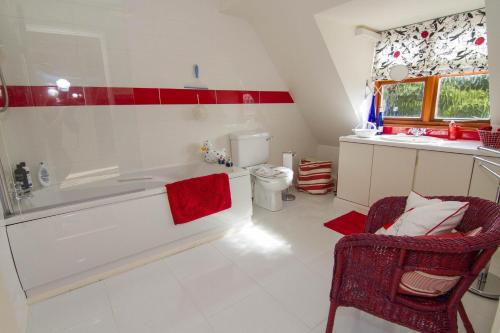 a bathroom with a tub and a chair and a sink at 2 Priory Court in Thornham