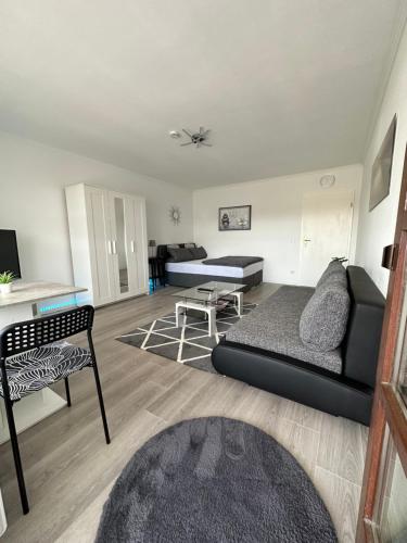 a living room with a couch and a table at Idyllisches Apartment - Moderne 1ZKB Balkon 2 Personen Self-Check-in 24h in Bad Nauheim