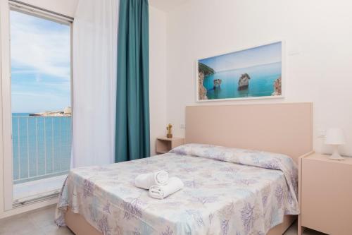 1 dormitorio con cama y ventana grande en Hotel Approdo di Venere, en Vieste