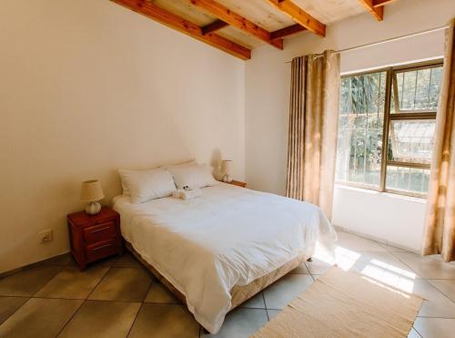 a bedroom with a bed and a large window at Golden Candle Guest House in Roodepoort