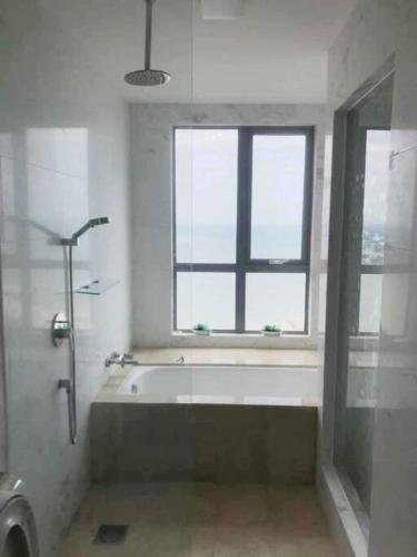 a bathroom with a bath tub and a window at Silverscape Residence Melaka Luxury Seaview Suite - FREE WIFI in Melaka