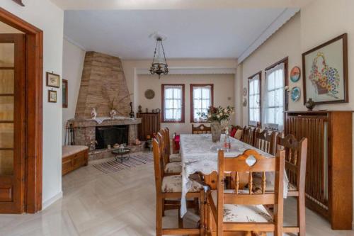 a dining room with a table and a fireplace at Villa Zina Agios Dimitrios in Agios Dimitrios