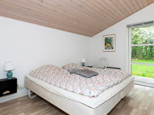 1 dormitorio con cama y ventana en Holiday home Vesløs IV en Øsløs