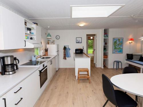 a kitchen with white cabinets and a table and a dining room at 6 person holiday home in Vesløs-By Traum in Øsløs