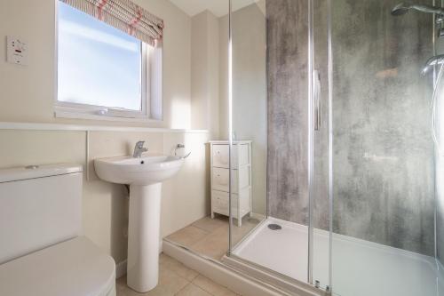 a bathroom with a shower and a toilet and a sink at Sea Lodge in Brancaster