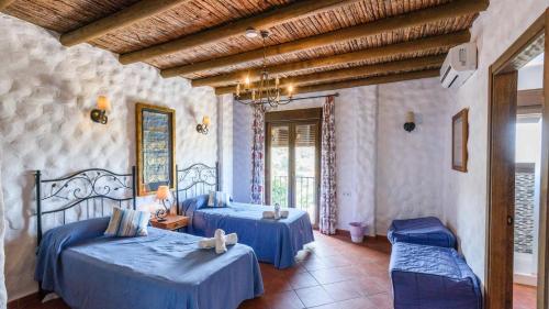 2 camas en una habitación con sábanas azules en Villa La Posada Canillas de Albaida by Ruralidays, en Canillas de Albaida