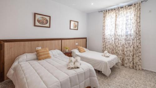 a bedroom with two beds and a window at La Antigua Fábrica Teba by Ruralidays in Teba