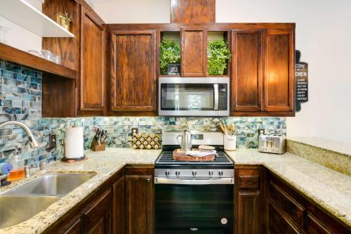 a kitchen with wooden cabinets and a black stove top oven at Tranquil Lake Almanor Getaway with Grill! in Westwood