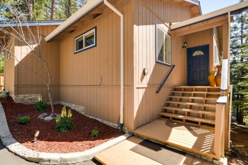 a small house with a blue door and stairs at Tranquil Lake Almanor Getaway with Grill! in Westwood