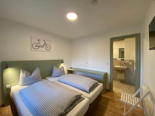 a bedroom with a bed with blue and white pillows at Bike Lodge Spessart in Lohr