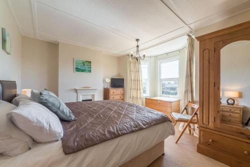 a bedroom with a large bed and a window at 4 Harbour View in Brancaster