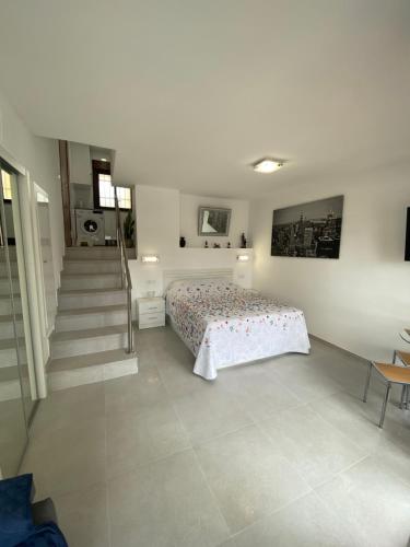 1 dormitorio con 1 cama y escalera en BENALMADENA ALOHA PLAYA BEACH LOFT en Benalmádena