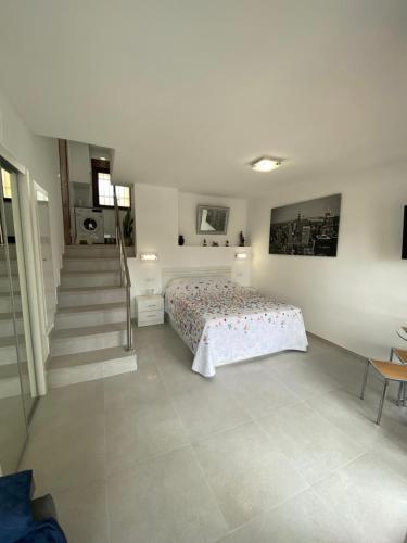 sypialnia z łóżkiem i schodami w obiekcie BENALMADENA ALOHA PLAYA BEACH LOFT w mieście Benalmádena