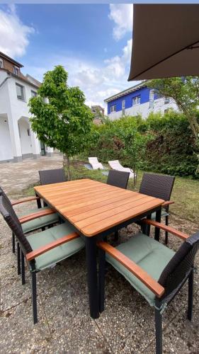 a wooden table with four chairs around it at Nisay Home - 3 Room Apartment - A1 in Ludwigsburg