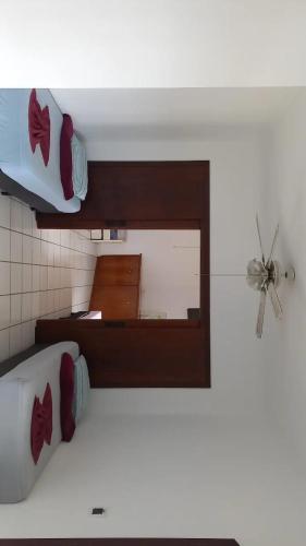 a bedroom with a bed with a mirror and a fan at Pousada Believe in Praia Grande
