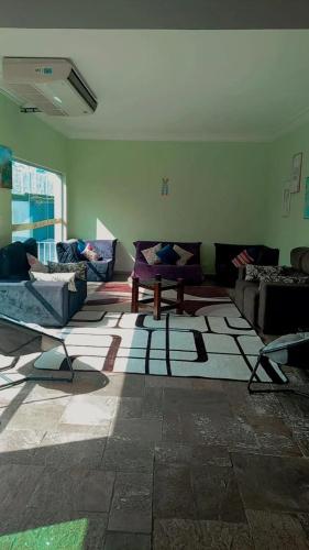 a living room with couches and a rug on the floor at Pousada Believe in Praia Grande