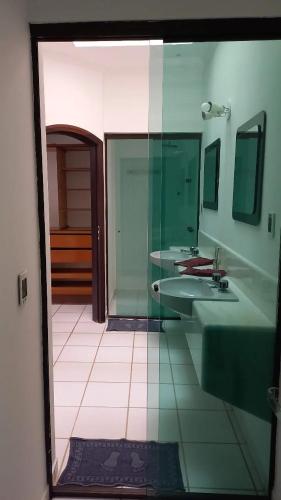 a bathroom with two sinks and two mirrors at Pousada Believe in Praia Grande