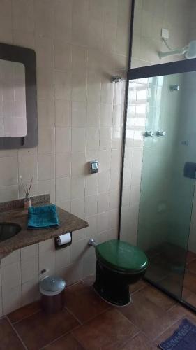 a bathroom with a green toilet and a sink at Pousada Believe in Praia Grande