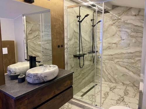 a bathroom with a glass shower and a sink at ZEN Hotel Focșani in Focşani