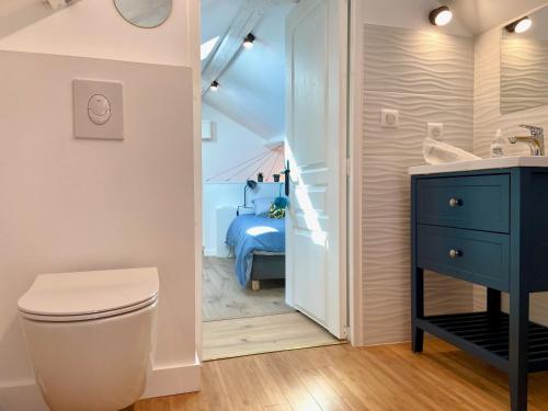 a bathroom with a toilet and a sink and a bedroom at La petite Maison Messigny in Messigny-et-Vantoux