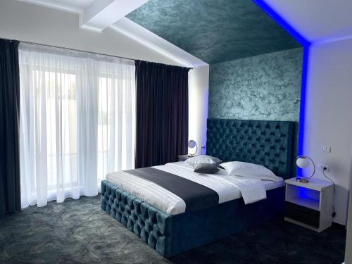 a bedroom with a large bed with a blue light at ZEN Hotel Focșani in Focşani