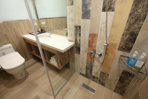 a bathroom with a toilet and a sink and a shower at Hai Sheng Wei B&B in Dahan